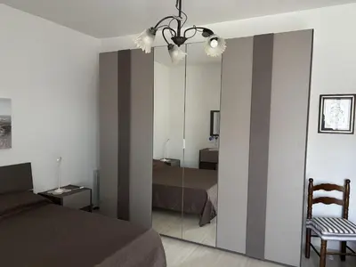 a bedroom with a bed and a mirror in it at Casa Maria Costa Blu in Isola delle Femmine