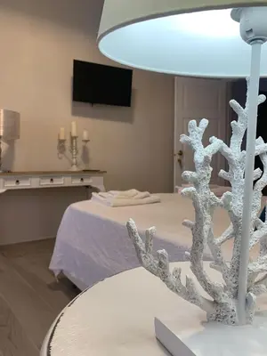 a white lamp in a room with a bed at Domus Federiciana in Castellammare del Golfo