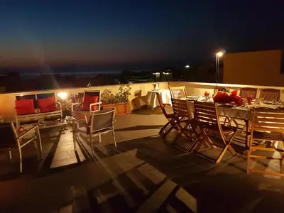 a table and chairs on a balcony at night at Malusi B&B in Sferracavallo