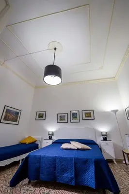 a bedroom with a blue bed and a ceiling at Le Case di Katy in Castellammare del Golfo