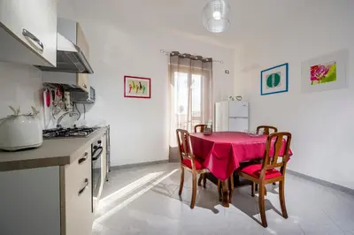 a kitchen with a table with a pink table cloth at Le Case di Katy in Castellammare del Golfo