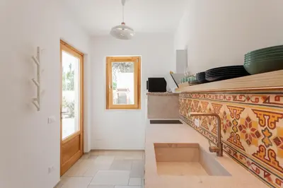 a kitchen with a counter with bowls and plates on it at Zizha Suite sul mare - San Vito Lo Capo in San Vito lo Capo