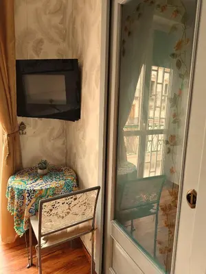 a room with a table and a window and a television at Studio Sedie Volanti in Palermo