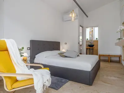 a bedroom with a bed and a yellow chair at Holiday Home Quirat by Interhome in Terrasini
