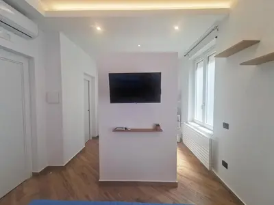 a living room with white walls and a flat screen tv at Maqueda Mood in Palermo