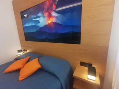 a bedroom with a bed with a large television on the wall at Maqueda Mood in Palermo
