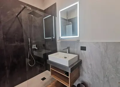 a bathroom with a sink and a shower and a mirror at Maqueda Mood in Palermo
