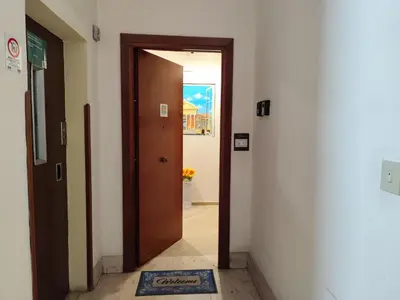 a hallway with a brown door and a blue rug at Kalatafimi- Palermo Apartment 2 Camere & Wi-Fi in Palermo