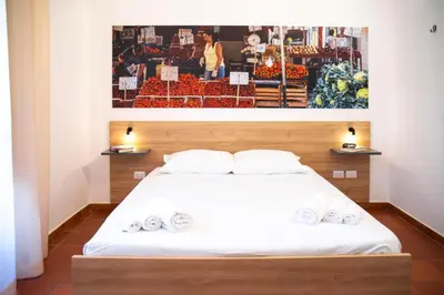a bedroom with a bed with a picture on the wall at Ballaro' Hotel - Budget Room in Palermo
