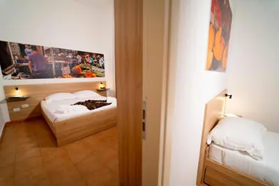 a room with two beds and a door to a bedroom at Ballaro' Hotel - Budget Room in Palermo