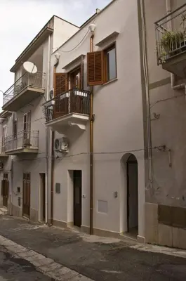 a large white building with balconies on a street at Casa vacanza Raggio di Sole in Castellammare del Golfo