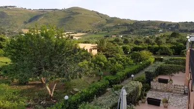 a dog standing in front of a house at Baglio Fico in Castellammare del Golfo