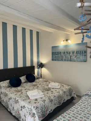 a bedroom with a bed and a painting on the wall at Mary Gery's Rooms in Castellammare del Golfo