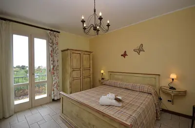 a bedroom with a bed and a large window at Catarin Comfort Rooms in Castelluzzo