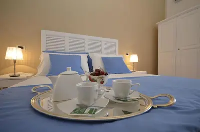 a tray with cups and saucers on a bed at Catarin Comfort Rooms in Castelluzzo