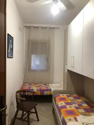 a small bedroom with a bed and a window at Casa Donatella a Isola in Isola delle Femmine
