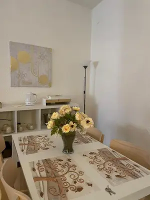 a dining room table with a vase of flowers on it at 100 PASSI Politeama in Palermo