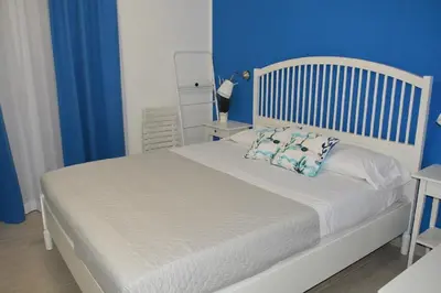 a bedroom with a white bed with blue walls at I colori del mare in Macari