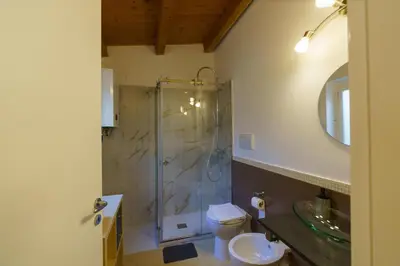 a bathroom with a shower and a toilet and a sink at Maquedino holiday home & Terrace - Cozy Central Loft in Palermo
