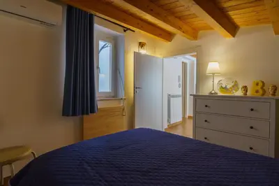 a bedroom with a blue bed and a dresser and a window at Maquedino holiday home & Terrace - Cozy Central Loft in Palermo
