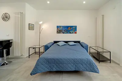 a bedroom with a blue bed and two side tables at AL BAYDA in Palermo