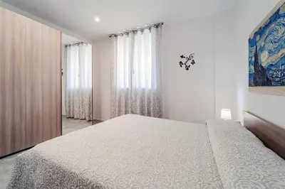 a white bedroom with a large bed and curtains at AL BAYDA in Palermo