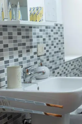a white sink with a cup on top of it at Bonorum Santa Sofia in Palermo
