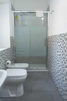 a bathroom with a shower and a toilet and a sink at Bonorum Santa Sofia in Palermo