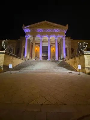 a building lit up at night with purple lights at Maqueda Suites in Palermo