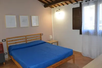 a bedroom with a blue bed and a window at Appartamento Casa Magnolia in San Vito lo Capo