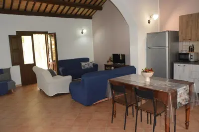 a living room with a blue couch and a table at Appartamento Casa Magnolia in San Vito lo Capo