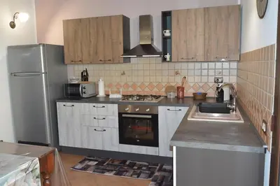 a kitchen with a sink and a refrigerator at Appartamento Casa Magnolia in San Vito lo Capo