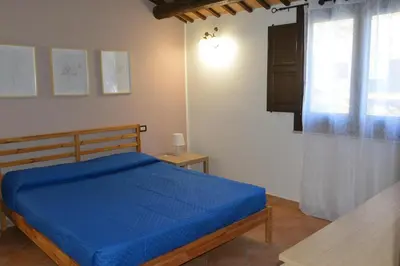 a bedroom with a blue bed and a window at Appartamento Casa Magnolia in San Vito lo Capo
