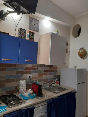 a kitchen with a sink and a stove and blue cabinets at CASA VACANZA DI VIA GIACALONE in Palermo