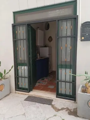 an entrance to a kitchen with green doors at CASA VACANZA DI VIA GIACALONE in Palermo