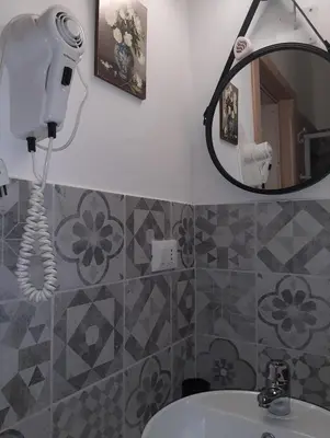 a bathroom with a hair dryer and a mirror at CASA VACANZA DI VIA GIACALONE in Palermo
