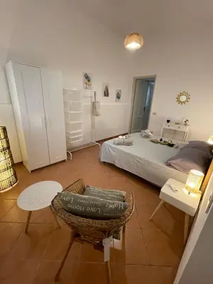 a bedroom with a bed and a chair and a table at Casa vacanze Baglio Barcellona Mondello in Palermo