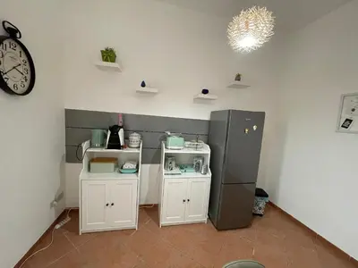 a kitchen with a refrigerator and a clock on the wall at Casa vacanze Baglio Barcellona Mondello in Palermo