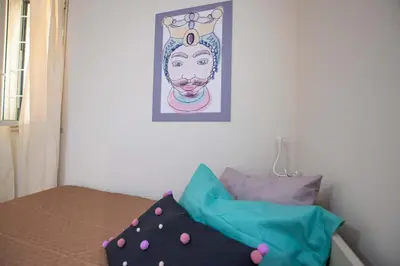 a room with a bed with a picture on the wall at Le case di Sofia in Isola delle Femmine
