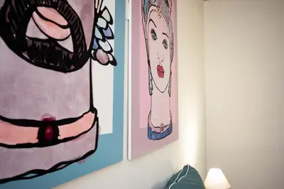 two paintings on the wall in a room at Le case di Sofia in Isola delle Femmine