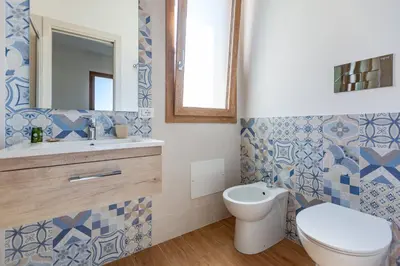 a bathroom with a toilet and a sink and a mirror at LA DAMA in San Vito lo Capo