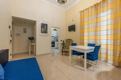 a living room with a table and blue chairs at Olivella Apartment al Teatro Massimo by Wonderful Italy in Palermo