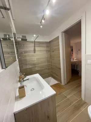 a bathroom with a white sink and a shower at Surfinia’s home in Palermo