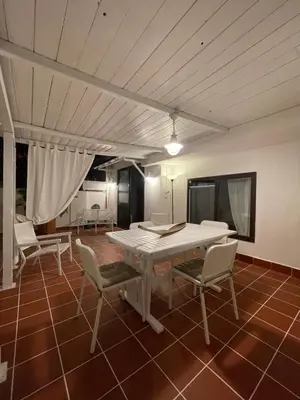 a dining room with a white table and chairs at Surfinia’s home in Palermo