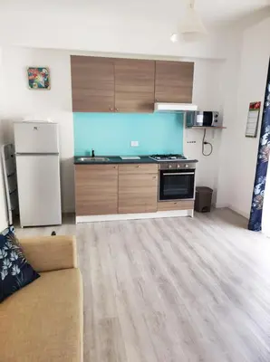 a kitchen with a couch and a stove and a refrigerator at B&B Puvogel in Porticello