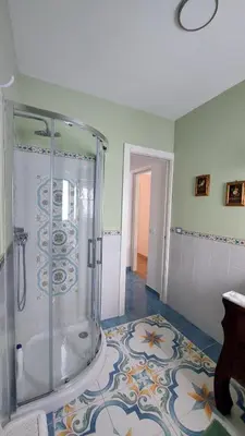 a bathroom with a shower and a tile floor at Elenahouse alla Kalsa in Palermo