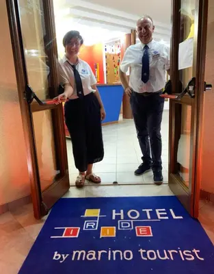 a man and a woman standing in front of a door at Hotel Iride by Marino Tourist in San Vito lo Capo
