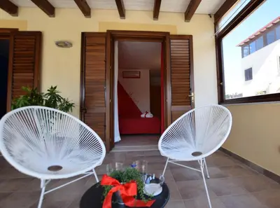 two white chairs and a table on a porch at Hotel Iride by Marino Tourist in San Vito lo Capo