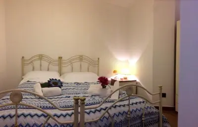 a bedroom with a bed with a blue and white quilt at Casa Longo in Castellammare del Golfo