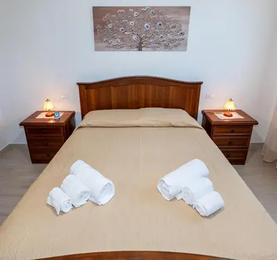 a bed with two towels on it with two tables at AL BARONE in Scopello